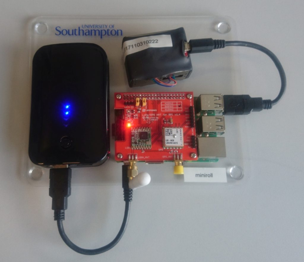 An Air Quality sensor node comprising of a perspex sheet with a battery bank, raspberry pi, lora HAT and particulate matter sensor attached